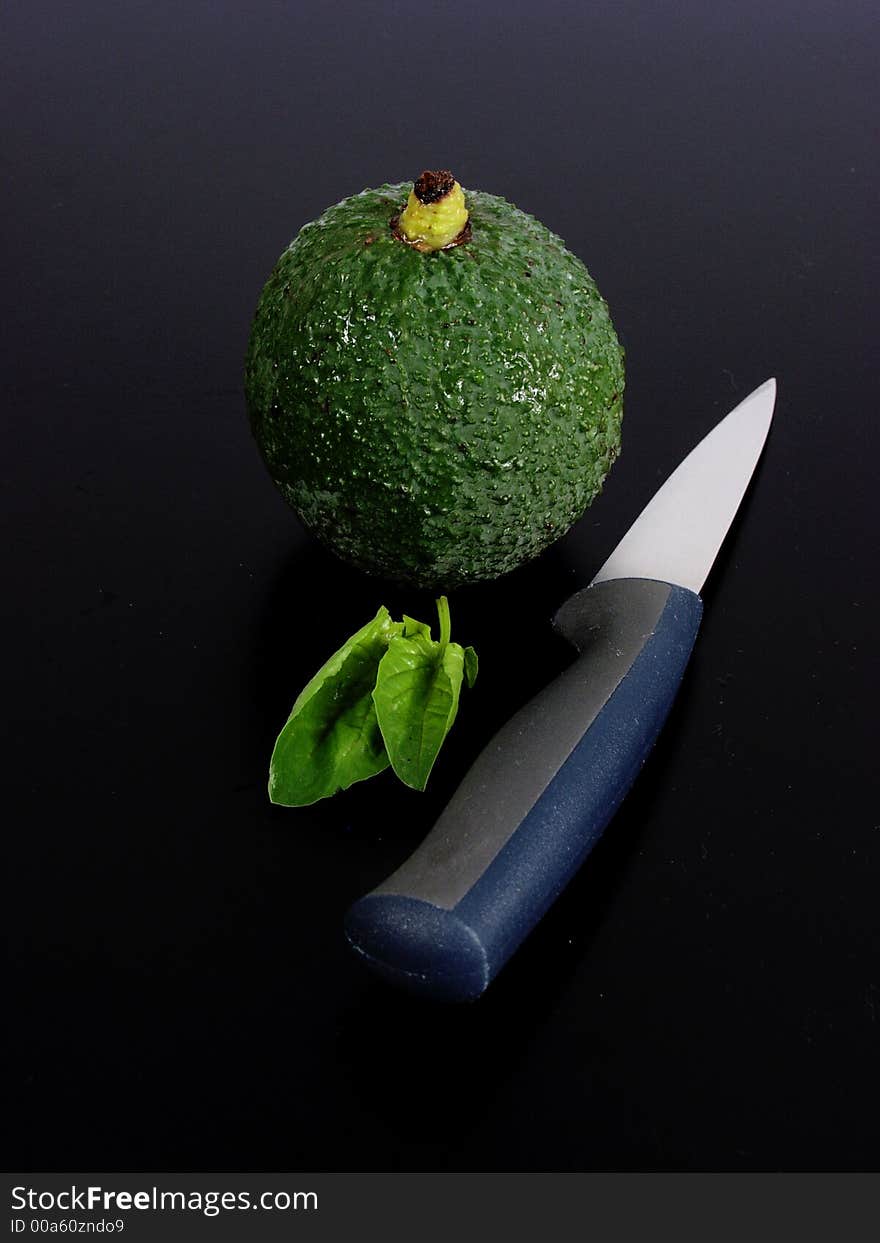 Composition whit green avocado, knife and leaves of spinach