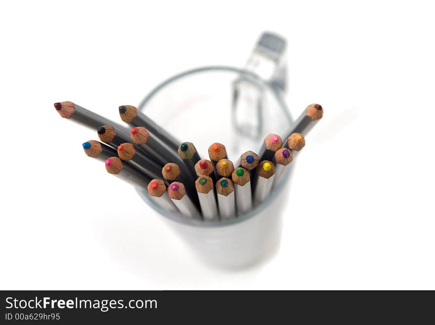 Colorful crayons in a glass cup isolated on white. Colorful crayons in a glass cup isolated on white