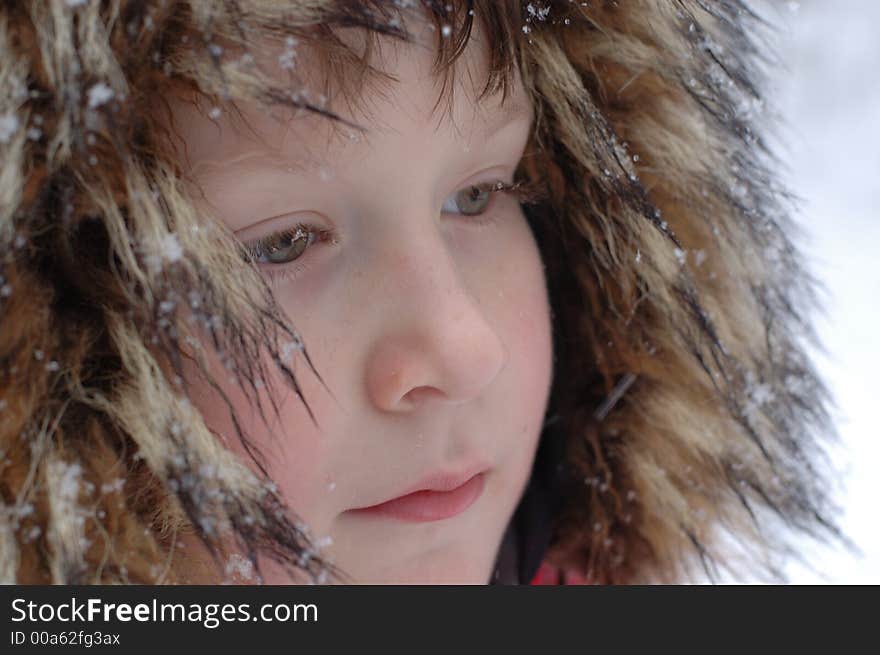 Portrait of young boy in fur hat covered with snow - side view - partial. Portrait of young boy in fur hat covered with snow - side view - partial