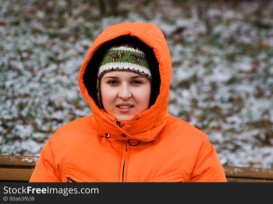 Young woman sitting on bench in a winter park. Young woman sitting on bench in a winter park