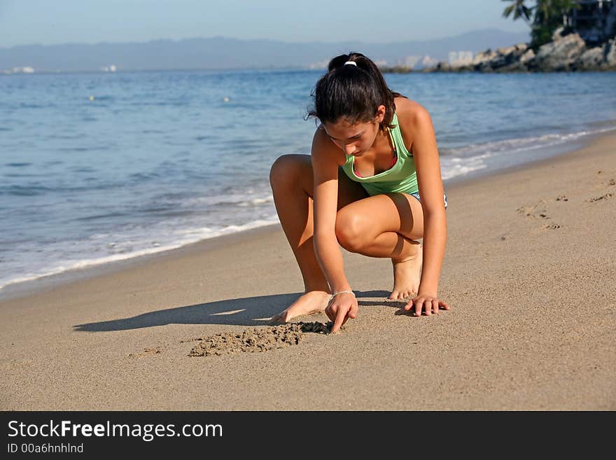 Girl drawing on the sand at the beach. Girl drawing on the sand at the beach