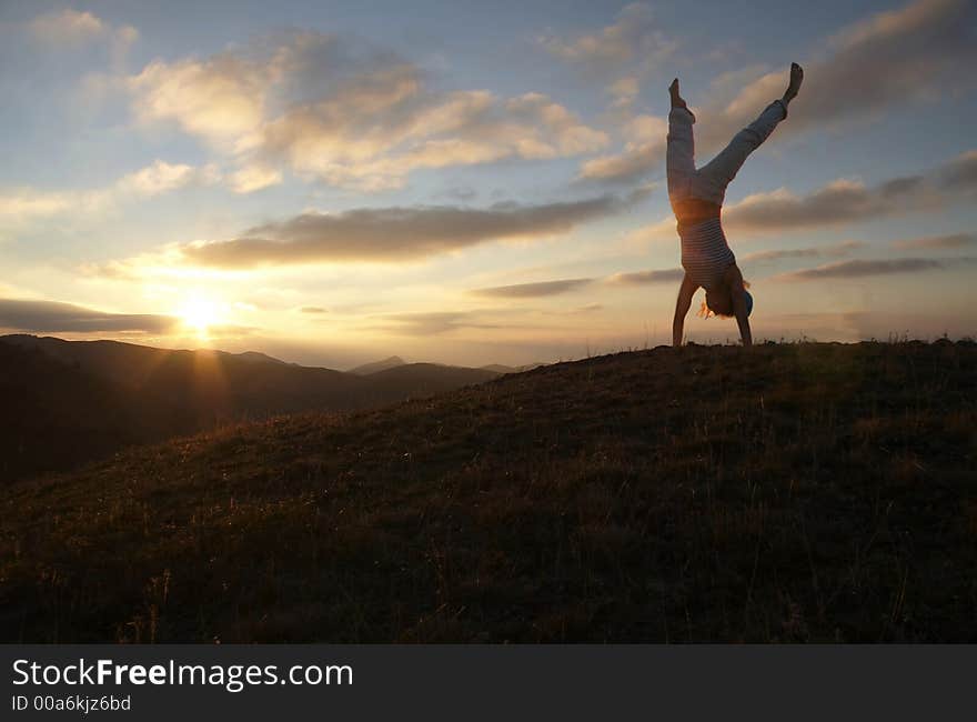 Acrobatic girl on sunset