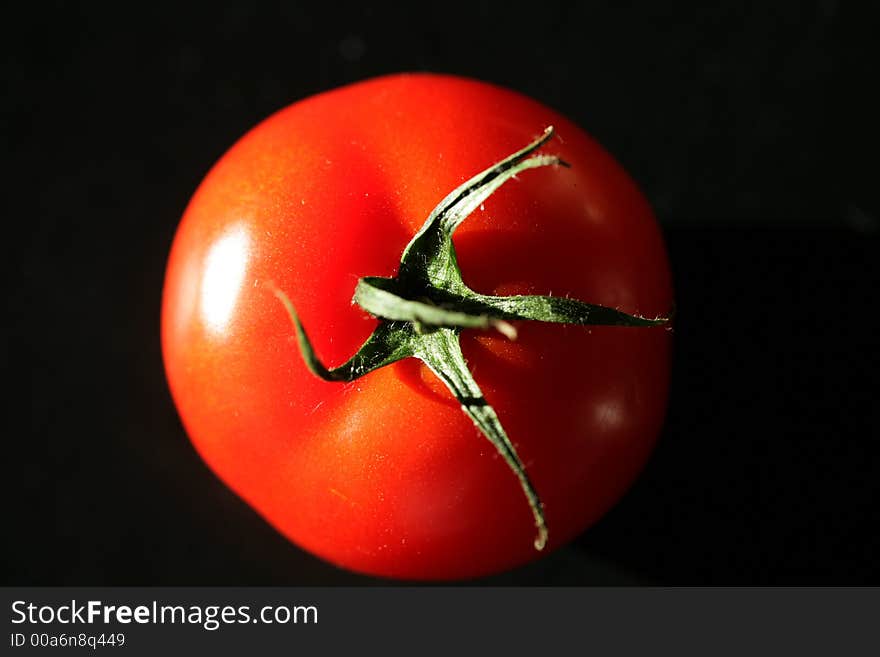 Tomato close up in natural light with dark background. Tomato close up in natural light with dark background