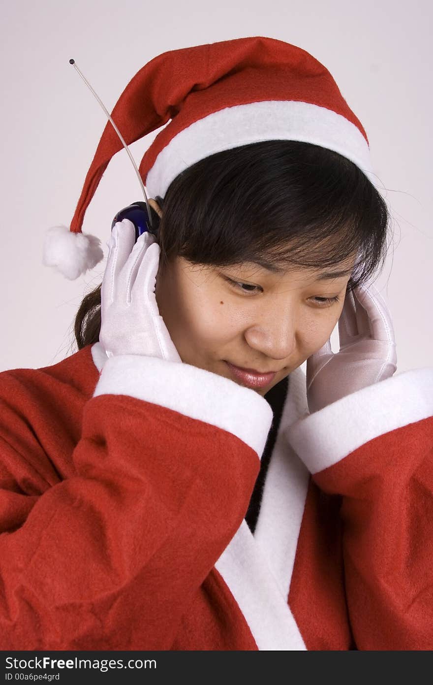 Asian Female Santa Claus listening mp3 music. Asian Female Santa Claus listening mp3 music.