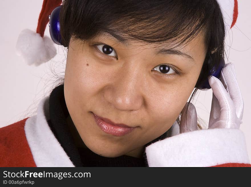 Asian Female Santa Claus listening mp3 music. Asian Female Santa Claus listening mp3 music.