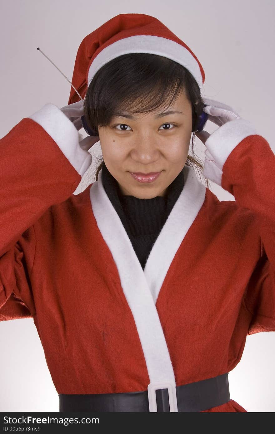 Asian Female Santa Claus listening mp3 music. Asian Female Santa Claus listening mp3 music.