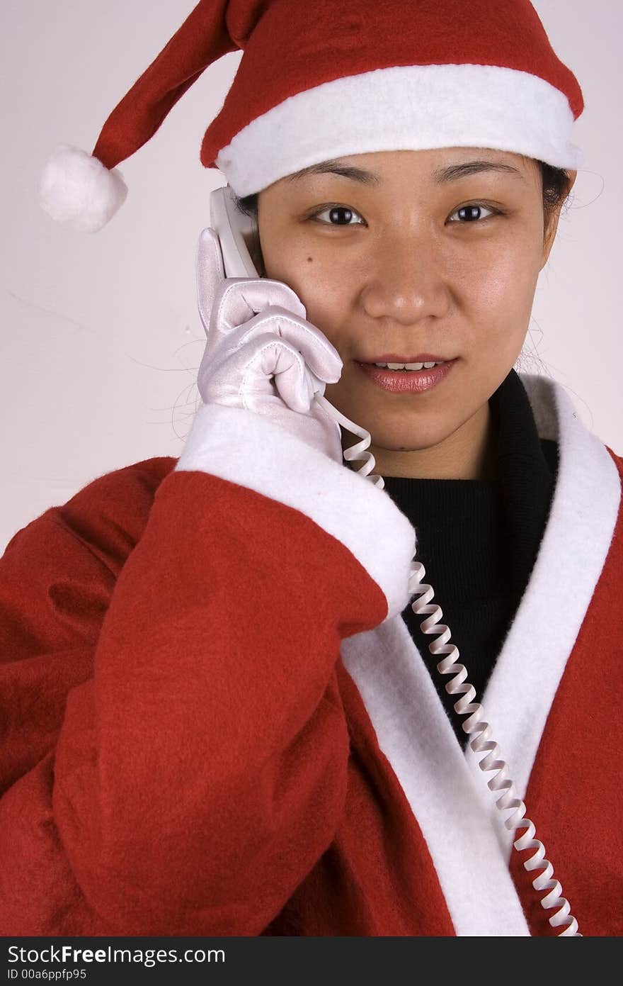 Asian female santa claus making a phone call. Asian female santa claus making a phone call.