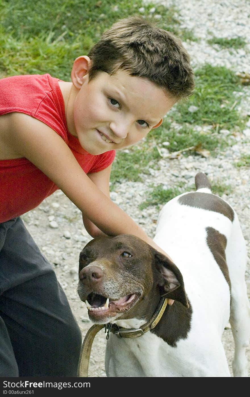 A boy reaches down to pet a dog. A boy reaches down to pet a dog.