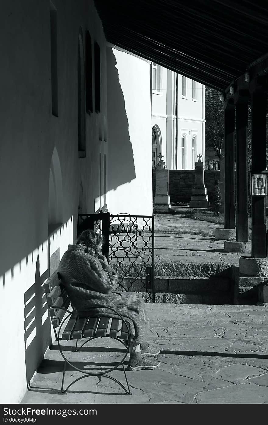 Old woman siting behind the church. Old woman siting behind the church