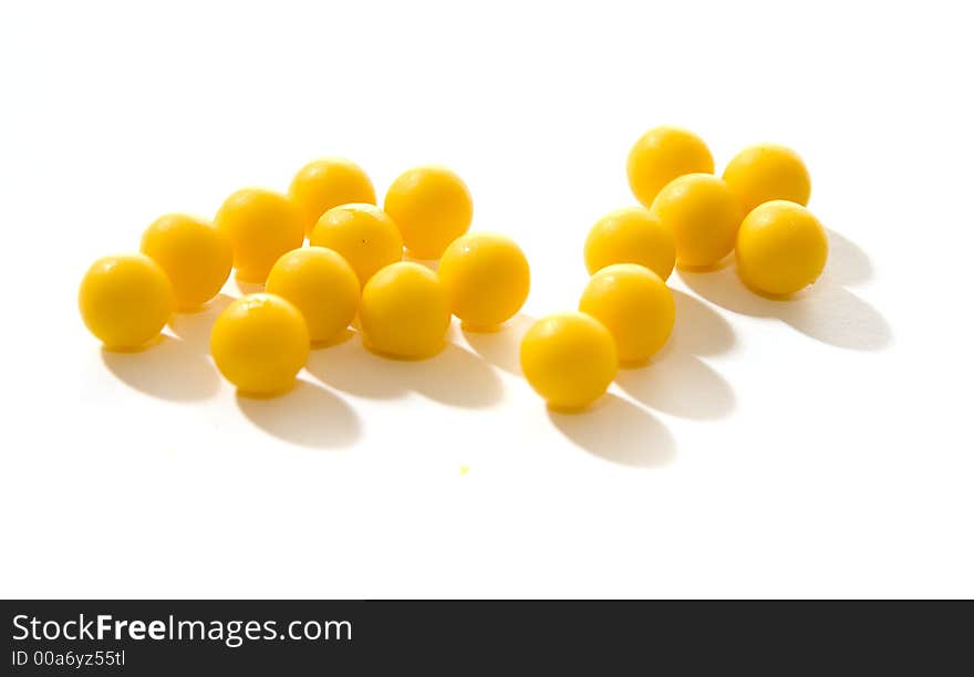 Yellow round pills of multivitamins on a white background