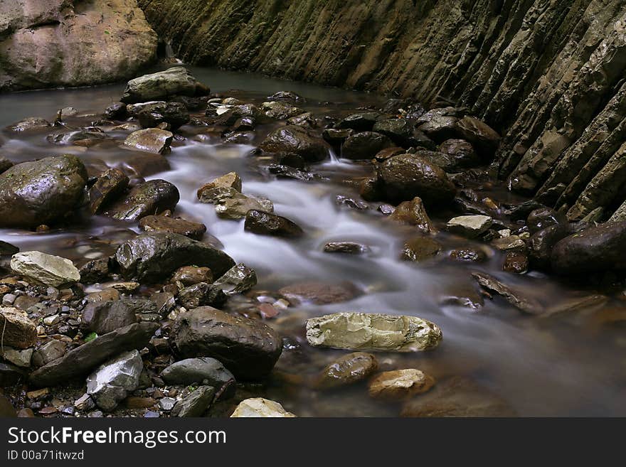 The stream runs between stones and rocks. The stream runs between stones and rocks