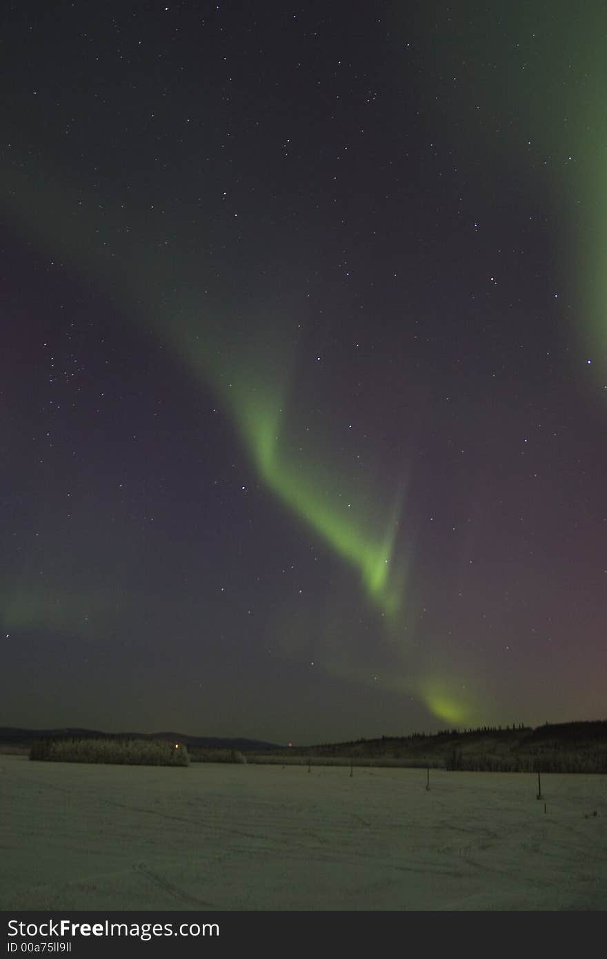 Faint northern lights arc in the sky. Faint northern lights arc in the sky