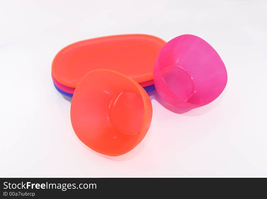 Colorful plastic plates and cups isolated over white