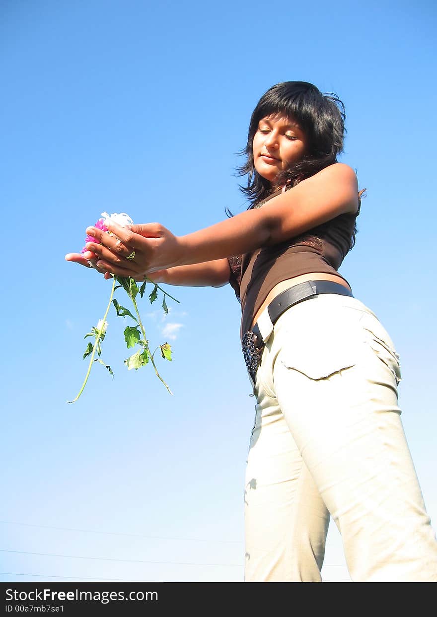 Brunette with flowers in hand during summer. Brunette with flowers in hand during summer