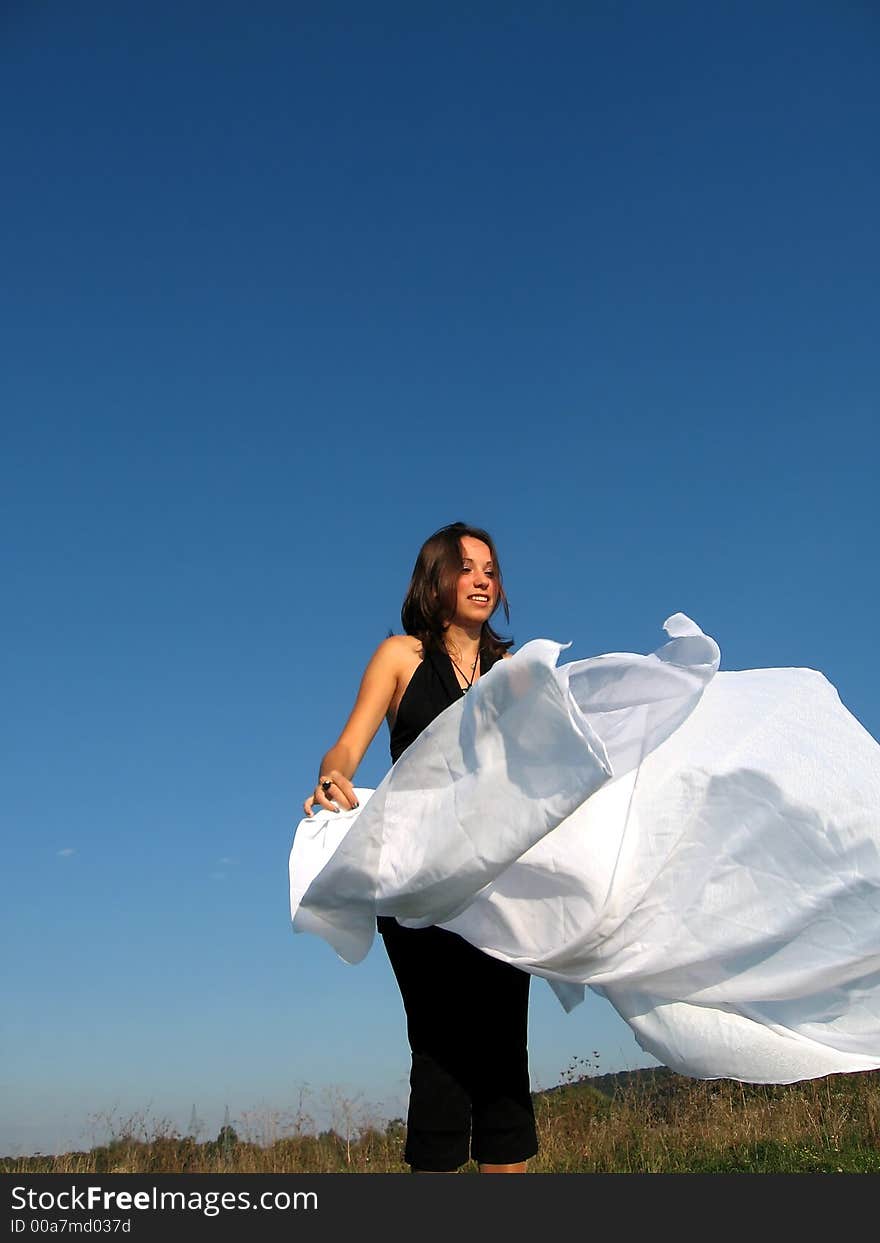 Beautiful girl playing with white silk in the summer. Beautiful girl playing with white silk in the summer