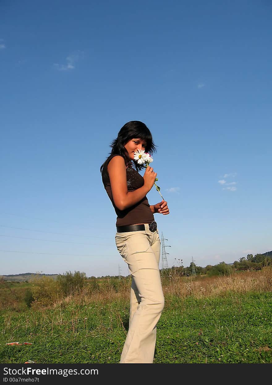 Brunette with flowers in hand during summer