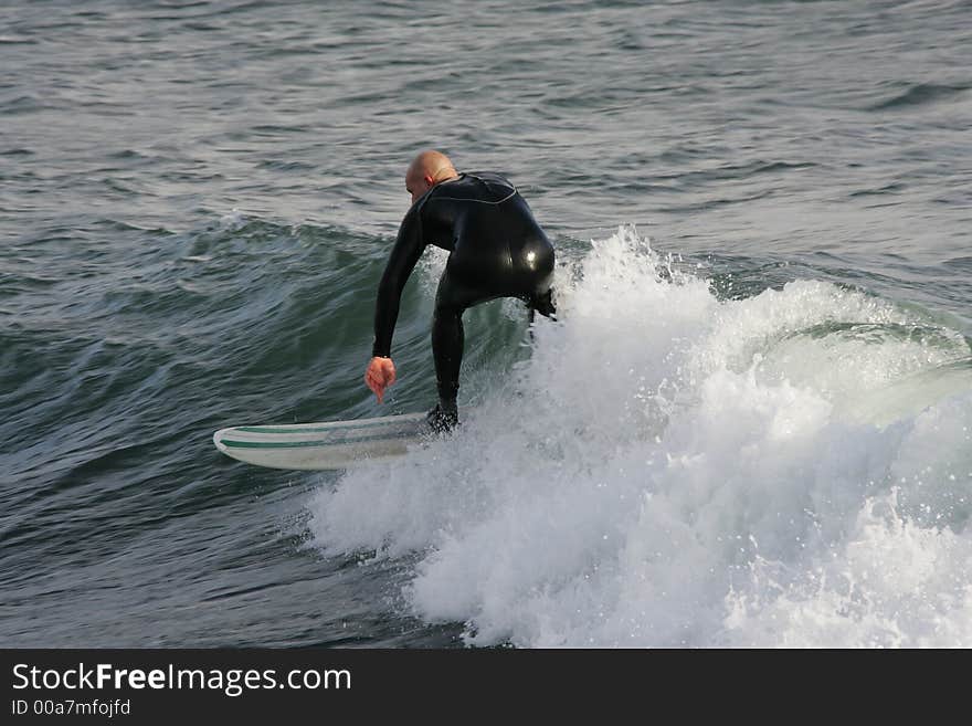 Surfer surfing in a low wave. Surfer surfing in a low wave