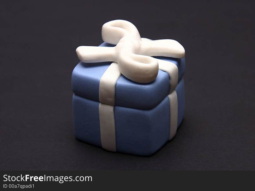 Blue Porcelain Gift Box with White Ribbon against black background