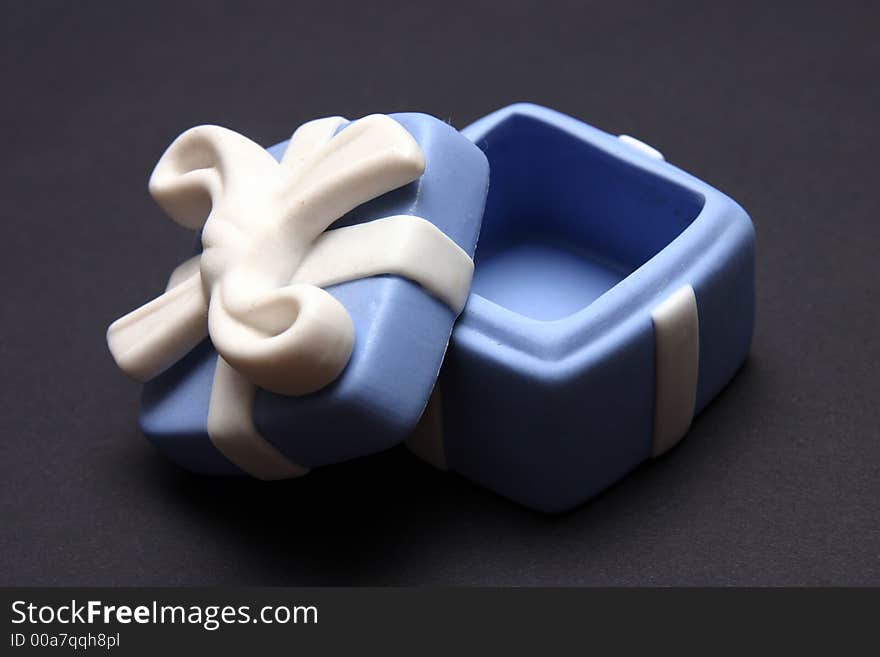 Blue Porcelain Gift Box with White Ribbon against black background