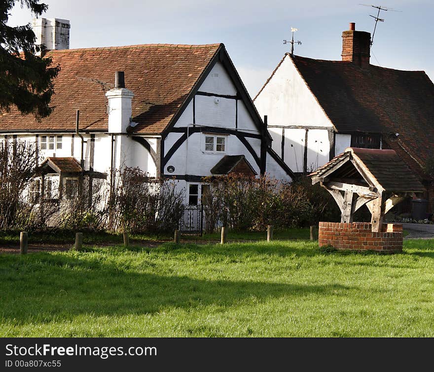 Timber Framed Cottages in a Rural in England with Village Well and Green in the foreground. Timber Framed Cottages in a Rural in England with Village Well and Green in the foreground