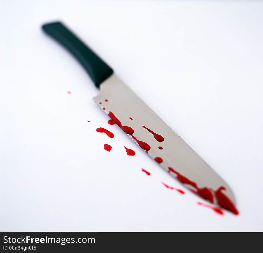 A Knife covered in blood on a white background. A Knife covered in blood on a white background.