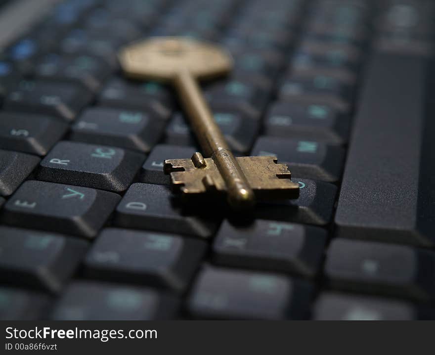 Vintage golden key on notebook computer keyboard. Vintage golden key on notebook computer keyboard