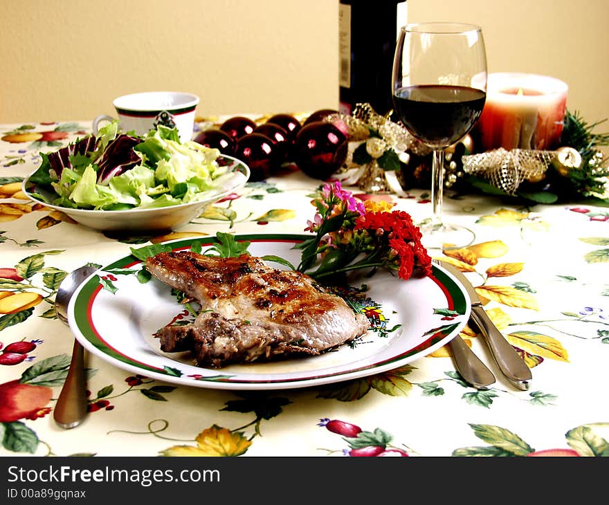 Decorated table for christmas dinner with pork steak grilled