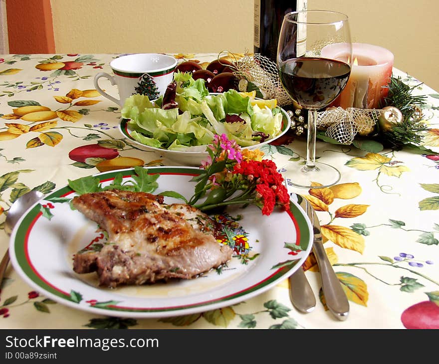 Decoration plater with pork steak, salad and red wine cup