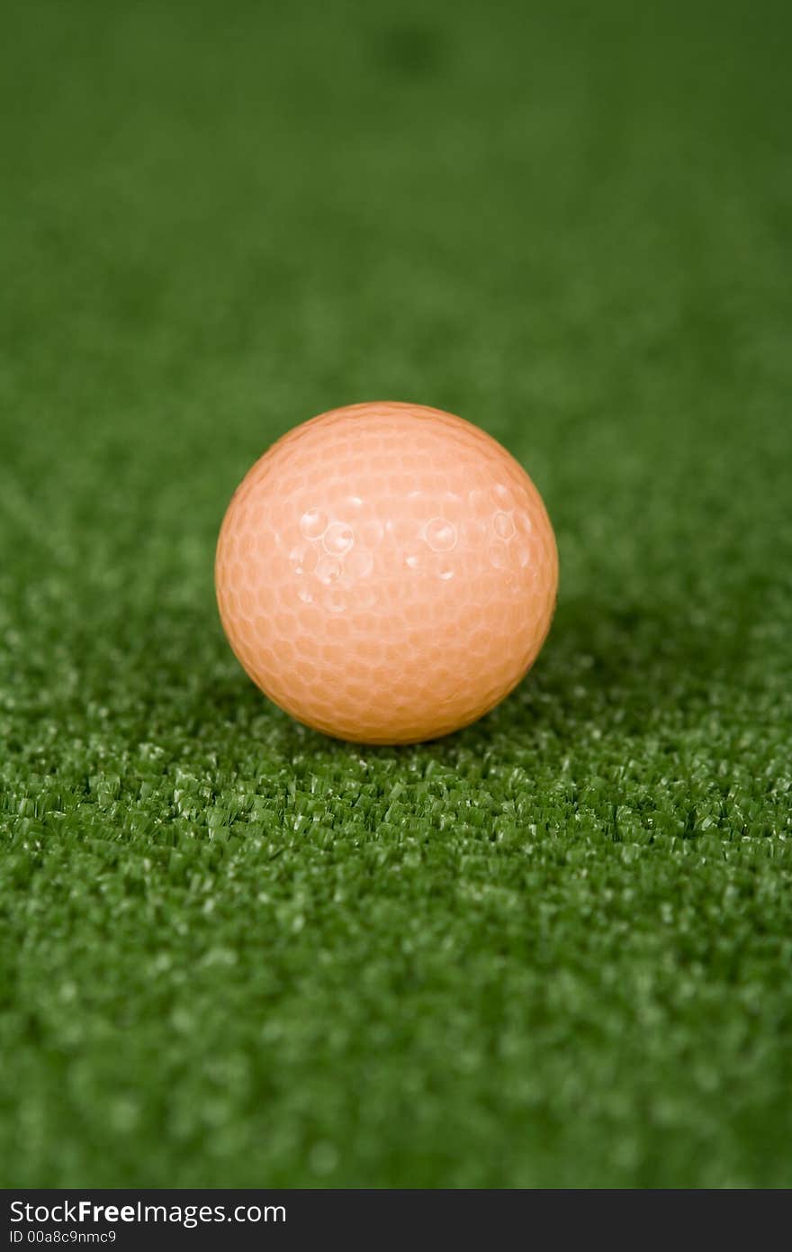 Picture of orange golf ball on practice tee