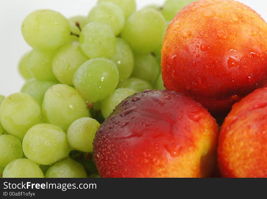 Colorful nectarines (peaches) and green grapes. Closeup. Colorful nectarines (peaches) and green grapes. Closeup.