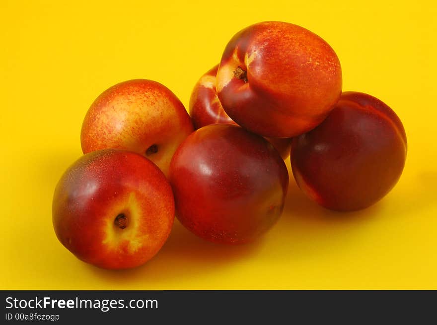 Colorful nectarines (peaches) over yellow background. Colorful nectarines (peaches) over yellow background.