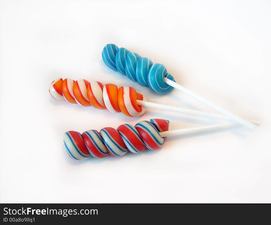 Multi-coloured a sugar candy on a stick on a white background