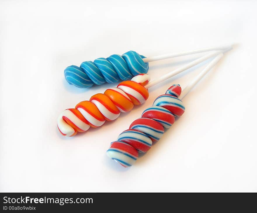 Multi-coloured a sugar candy on a stick on a white background