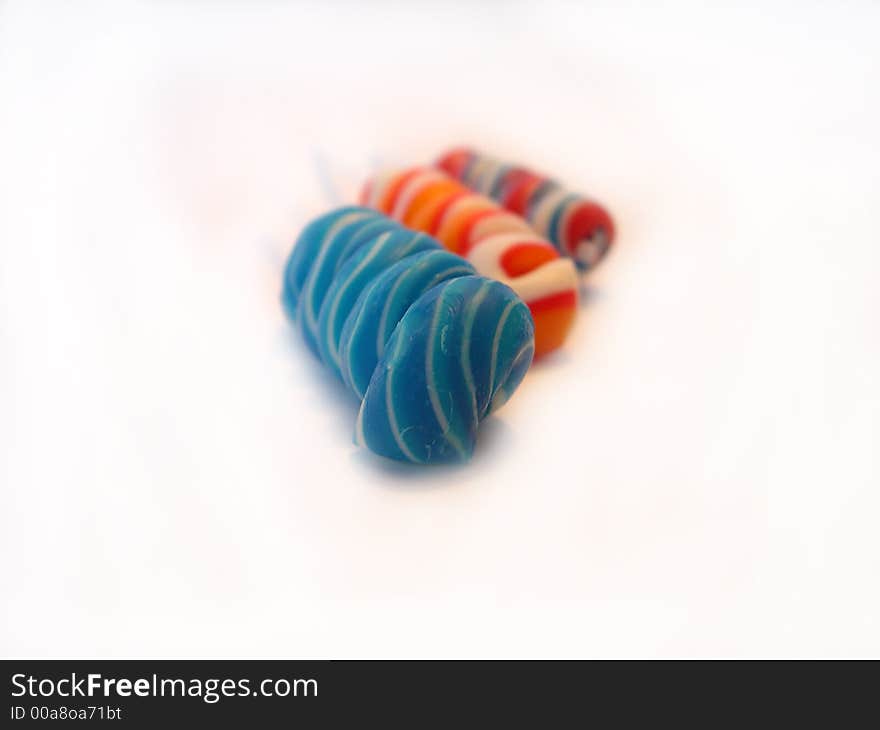 Multi-coloured a sugar candy on a stick on a white background