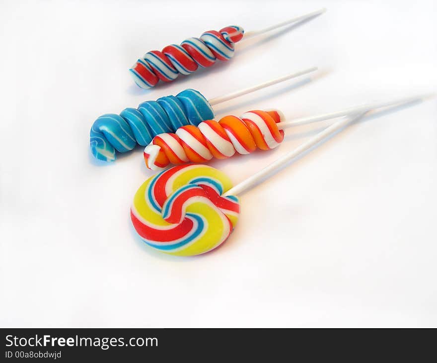 Multi-coloured a sugar candy on a stick on a white background