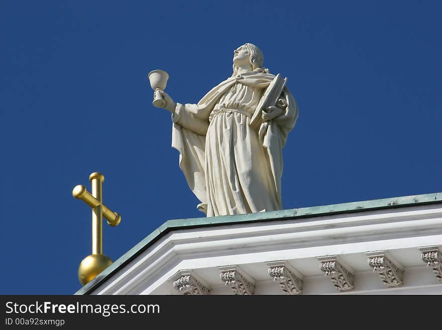 A White marble statue holding a chalice cup. A White marble statue holding a chalice cup