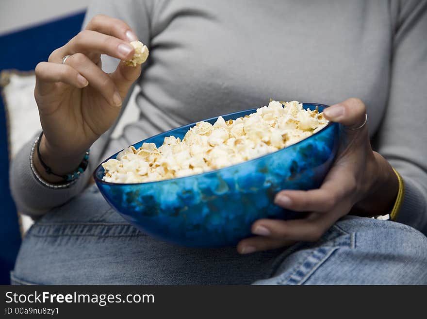 Girl eating popcorns while watching tv at home. Girl eating popcorns while watching tv at home