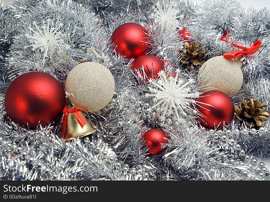 Red and silver globes on tinsel background with snowflakes pine cones christmas decorations