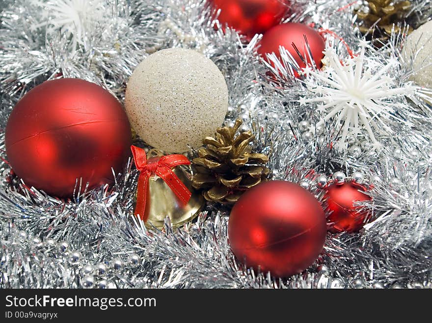 Red and silver globes on tinsel background with snowflakes pine cones christmas decorations