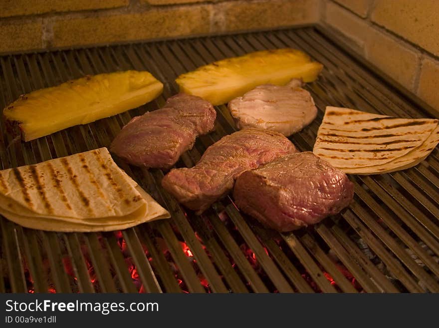 Appetizing pieces of pork and beef meat with pines roasting on grid. Appetizing pieces of pork and beef meat with pines roasting on grid