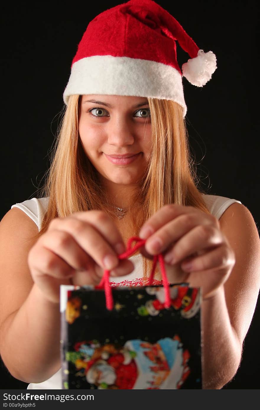 Christmas blonde girl offer a gift in a bag, black background. Christmas blonde girl offer a gift in a bag, black background