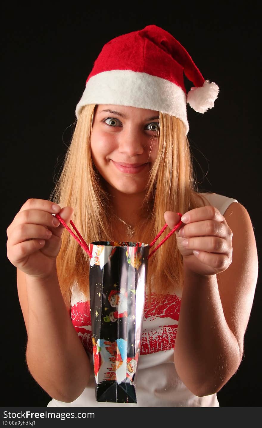 Christmas blonde girl offer a gift in a bag, black background. Christmas blonde girl offer a gift in a bag, black background