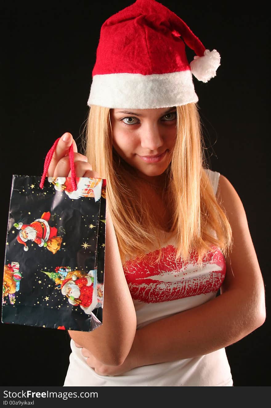 Christmas blonde girl offer a gift in a bag, black background. Christmas blonde girl offer a gift in a bag, black background