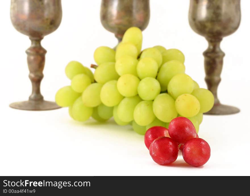 Close up of grapes with vintage wine glasses isolated on white - narrow focus