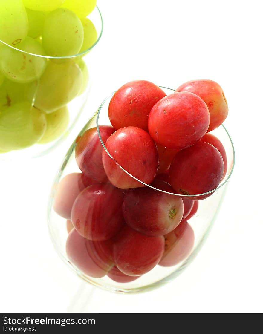 High key image of grapes in the wine glasses isolated on white. High key image of grapes in the wine glasses isolated on white