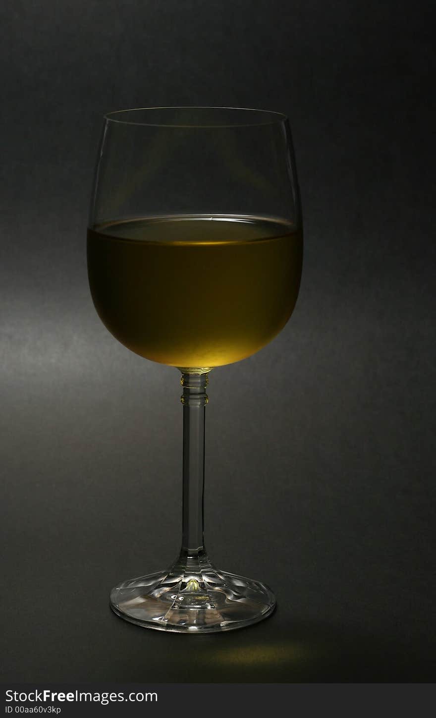 Glass of chilled white wine against dark background. Glass of chilled white wine against dark background