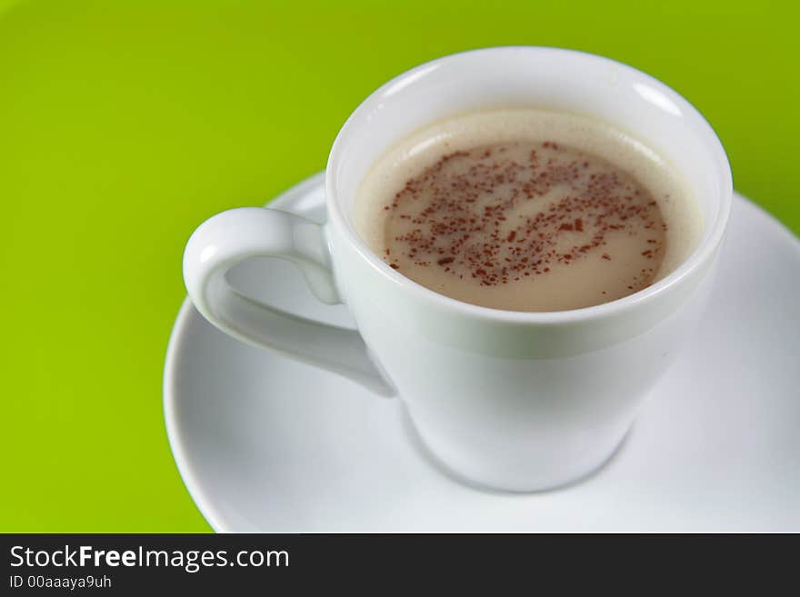 Cup of Cappucino coffee with Copyspace (green background)