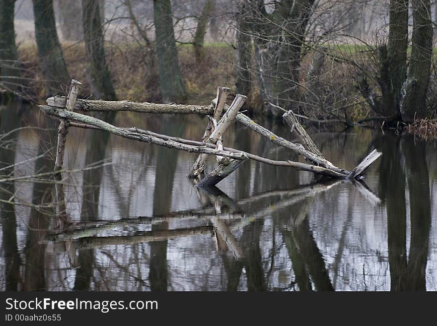 Fall pond with wooden construction. Variety of nice light reflections on the water surface. Fall pond with wooden construction. Variety of nice light reflections on the water surface.