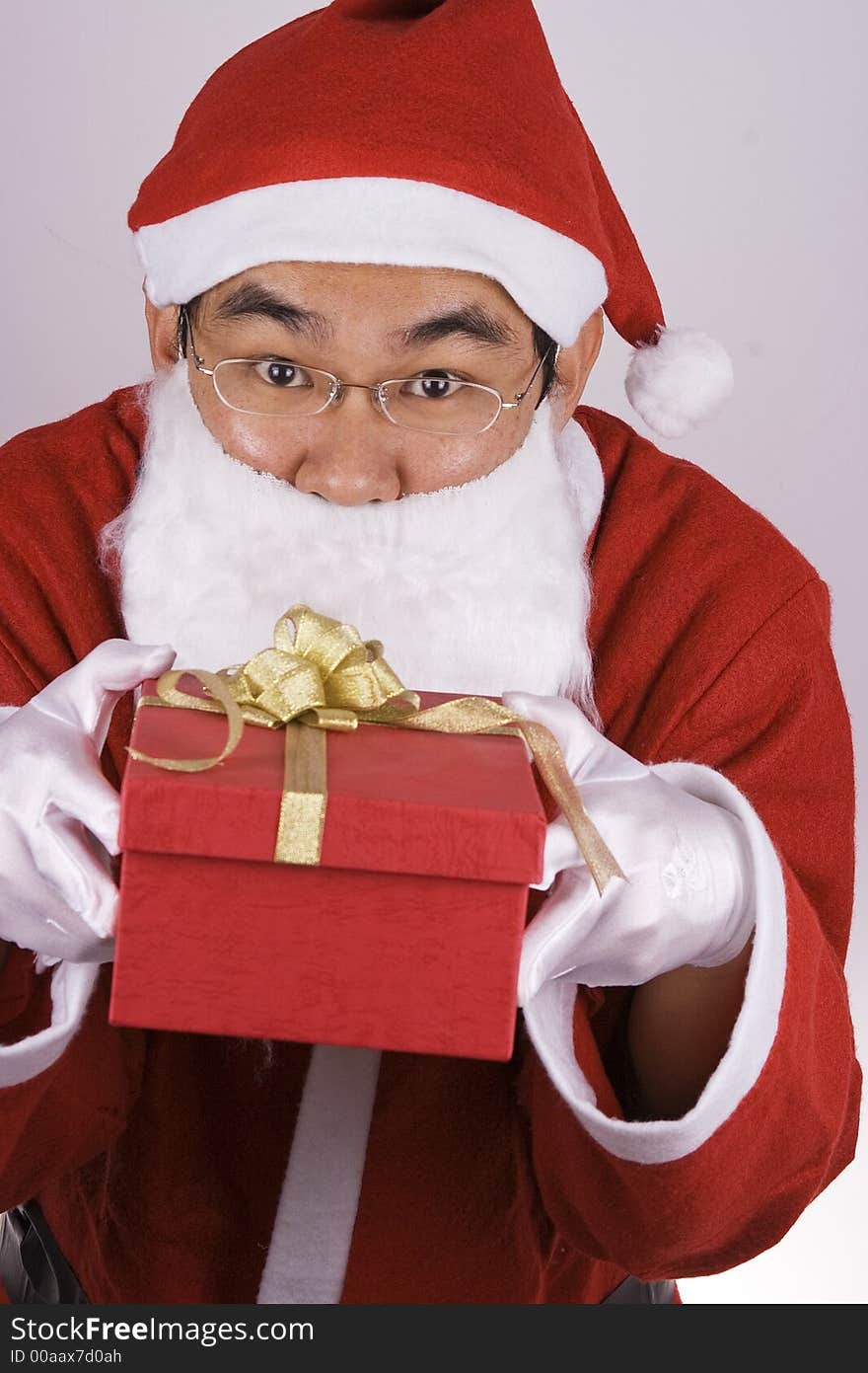 An Asian Santa Claus holding a gift box. An Asian Santa Claus holding a gift box.