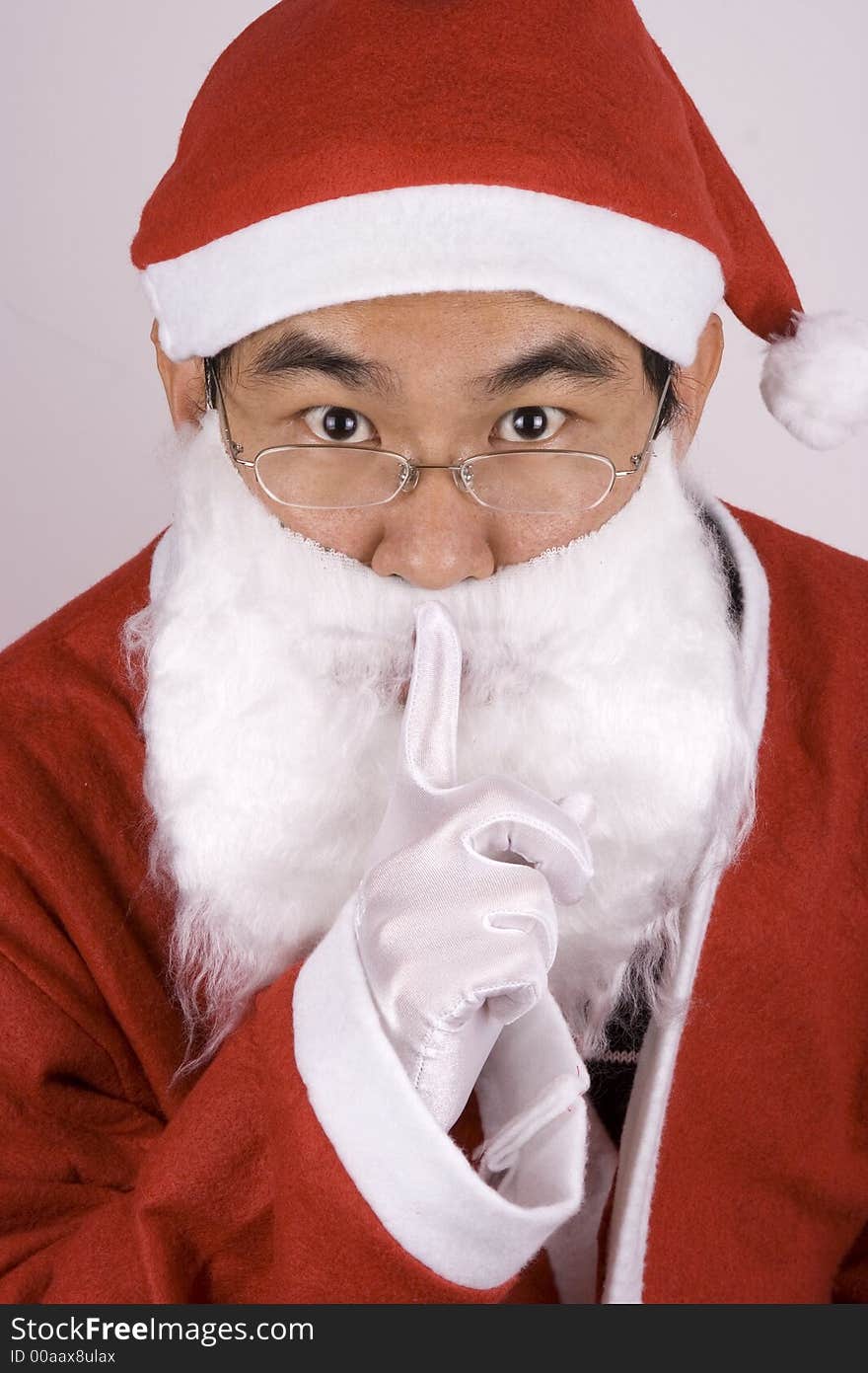 Asian santa claus showing a whispering gesture. Asian santa claus showing a whispering gesture.